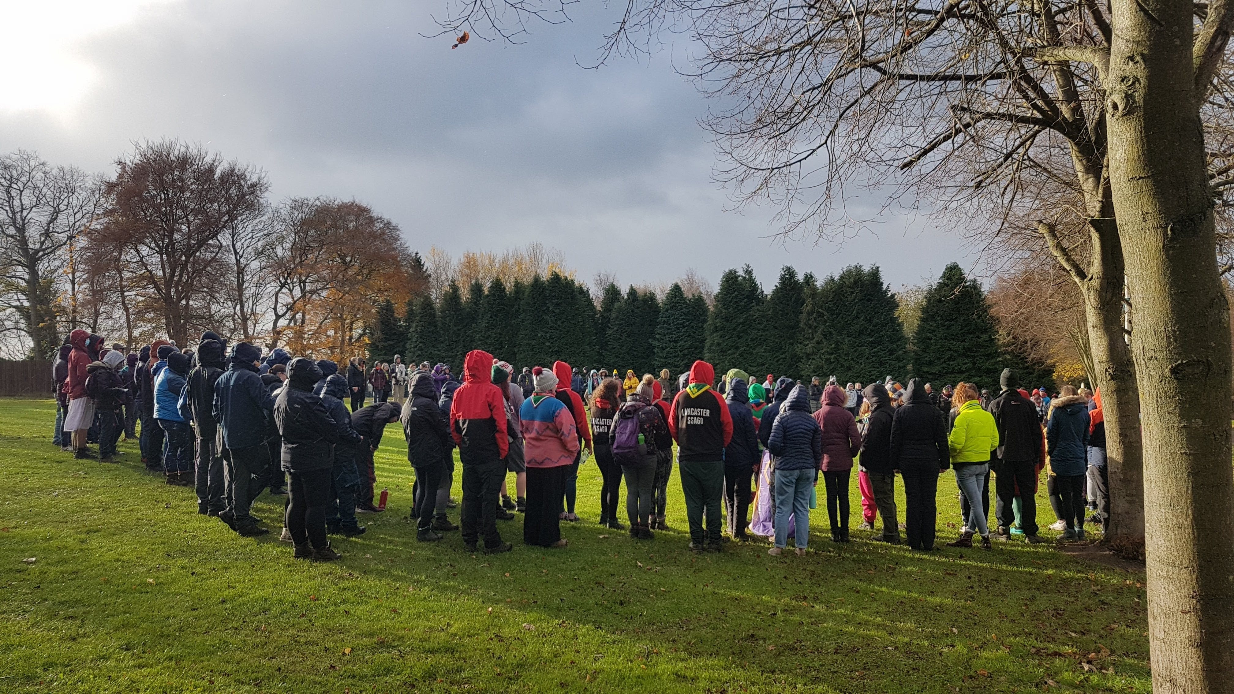 A wide shot from the side of the closing ceremony, with all attendees in a circle